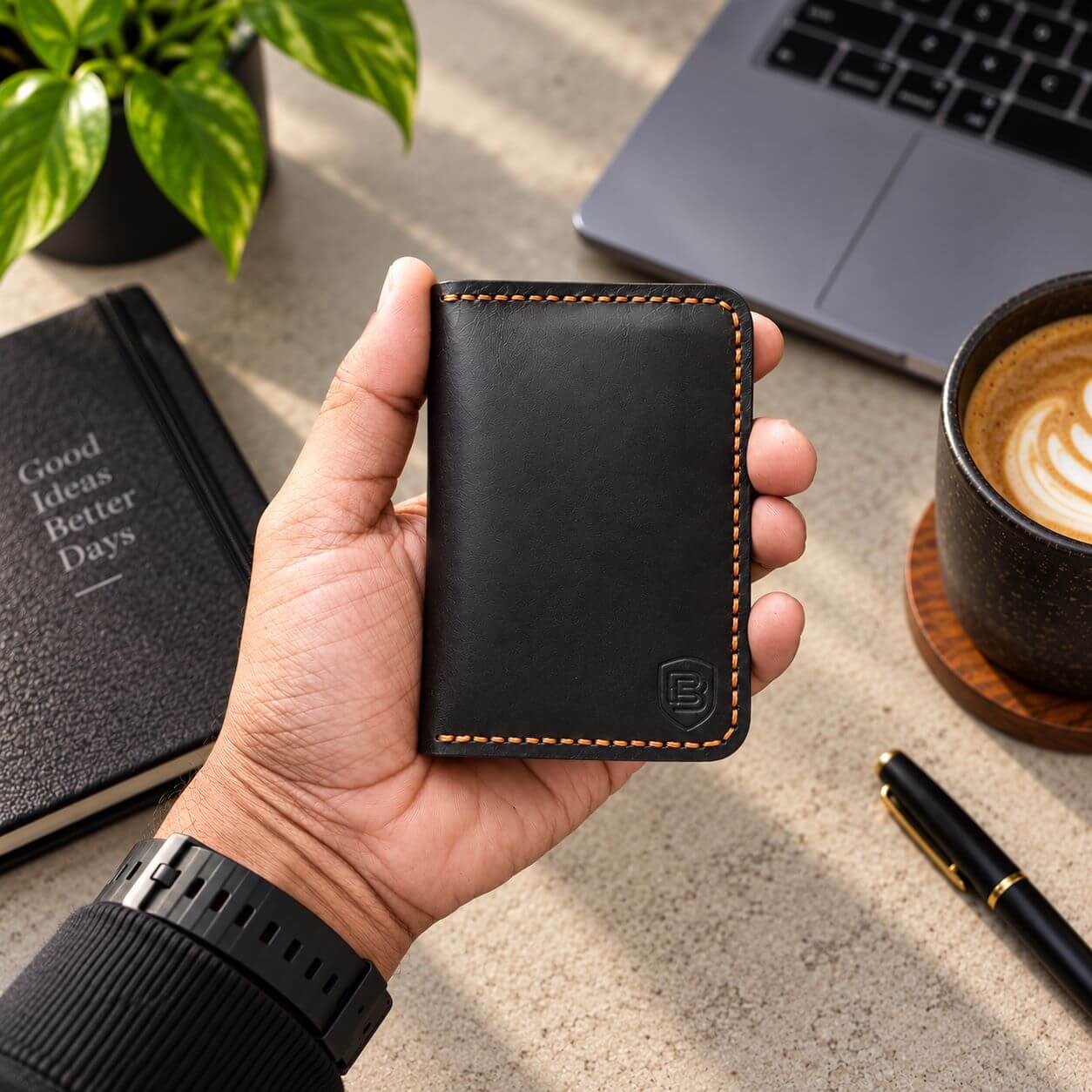 Handmade black leather card holder held in hand for size reference